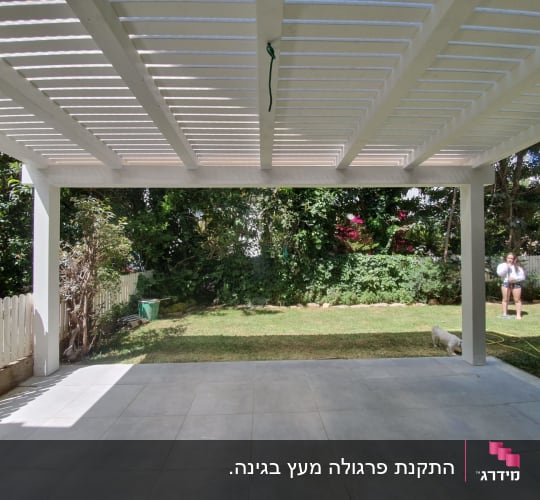 פרגולה מעץ לבן בגינה עם דשא ירוק